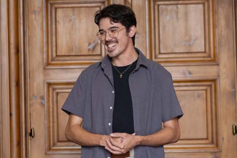 male student standing smiling