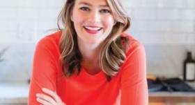 Sarah Jones Garibaldi poses with a plate of cookies in a kitchen.