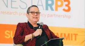 Susan Dawson sits holding a microphone as she speaks at the LONESTARP3 Summit.