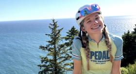 graduate student in bike helmet smiling outside