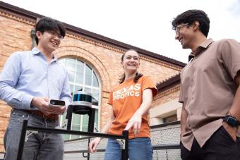 three students standing outside talking