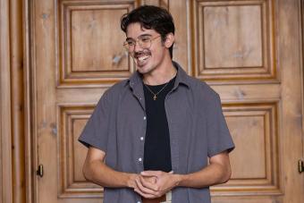 male student standing smiling