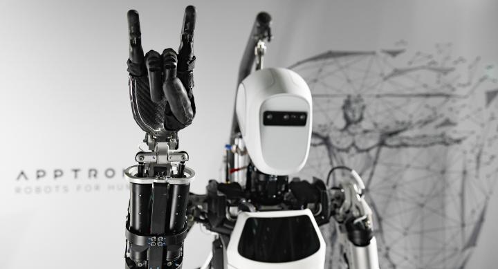 A robot does the Hook 'em hand sign.