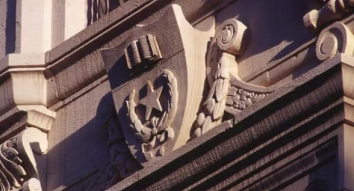 A stone emblem carved on an academic building.
