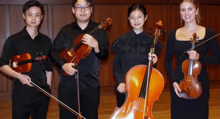 Four students pose with their string instruments.