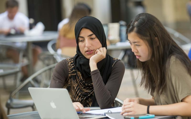 students sitting at table with computer